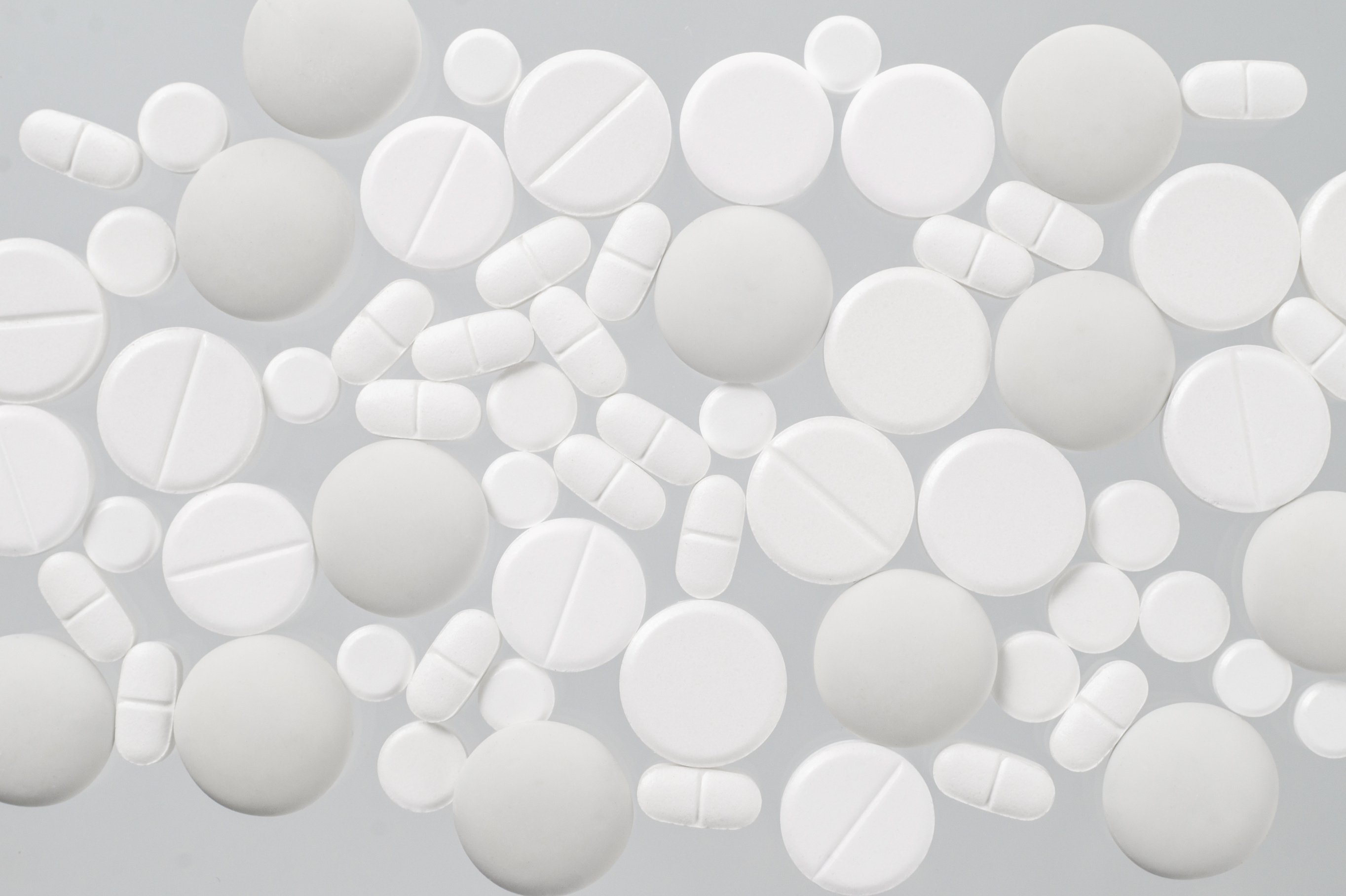 Various White Medical Pills on White Background
